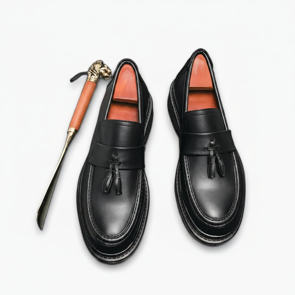 Mocassin à tête cuivrée en cuir verni noir avec pampilles décoratives