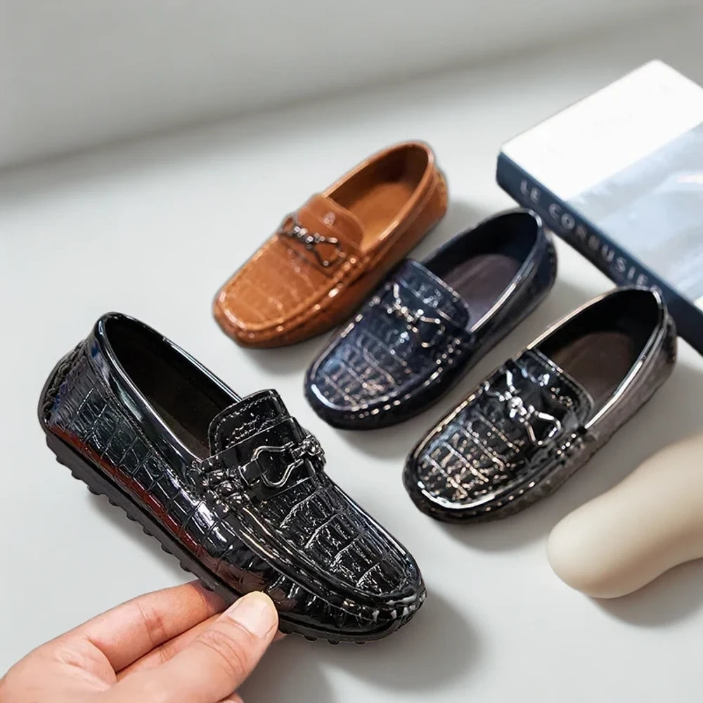 Gros plan boucle métal brillante sur mocassin croco garçon