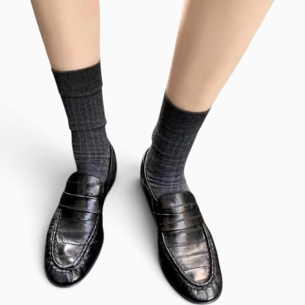 Mocassin femme en cuir noir porté avec des chaussettes grises