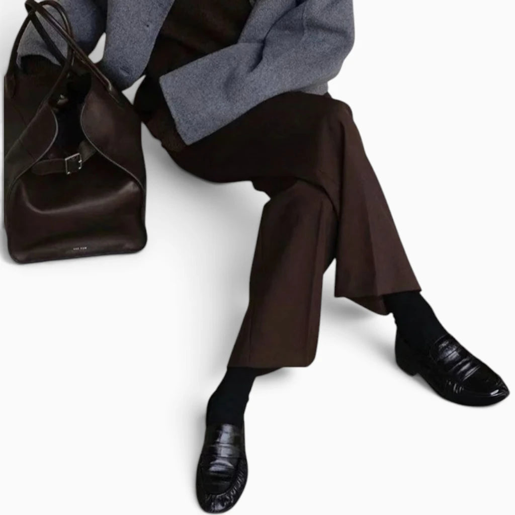 Mocassin femme en cuir noir porté assis, allure de bureau