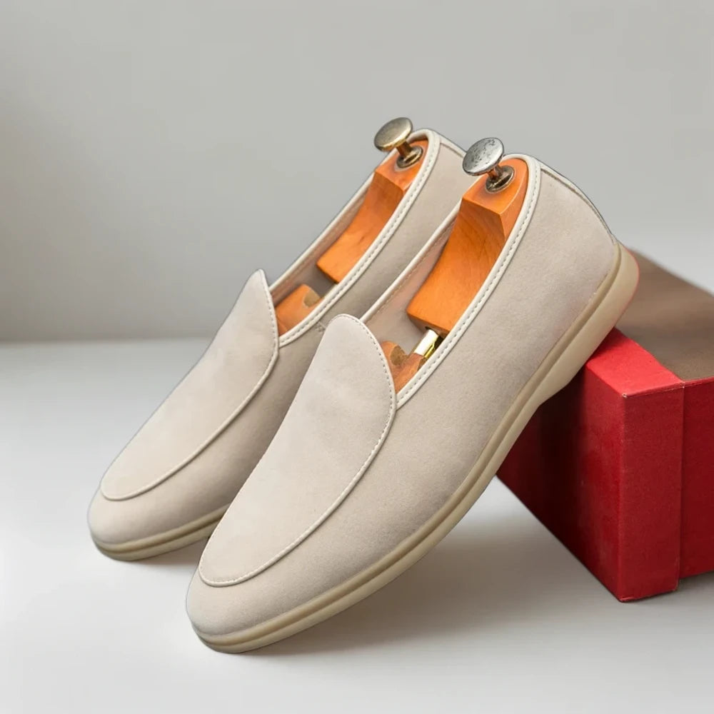 Mocassins daim beige homme posés sur surface en bois naturel