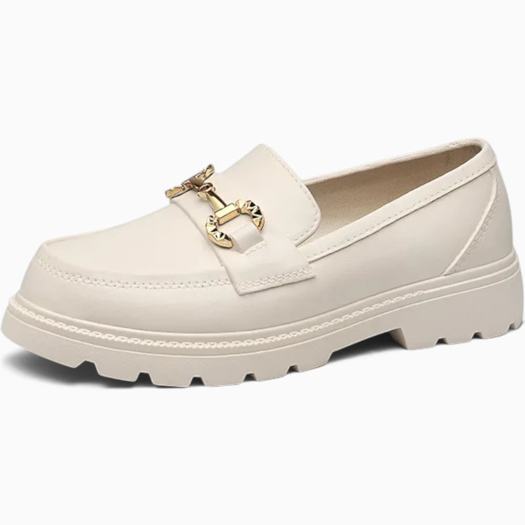 Mocassin souple blanc avec boucle dorée et semelle crantée épaisse, présenté de profil