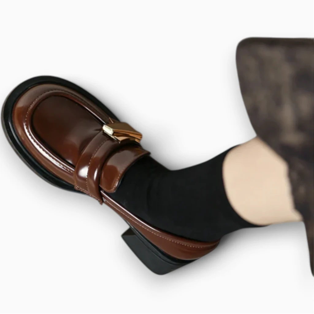 Détail du dessus synthétique noir du mocassin compensé et de la découpe confortable