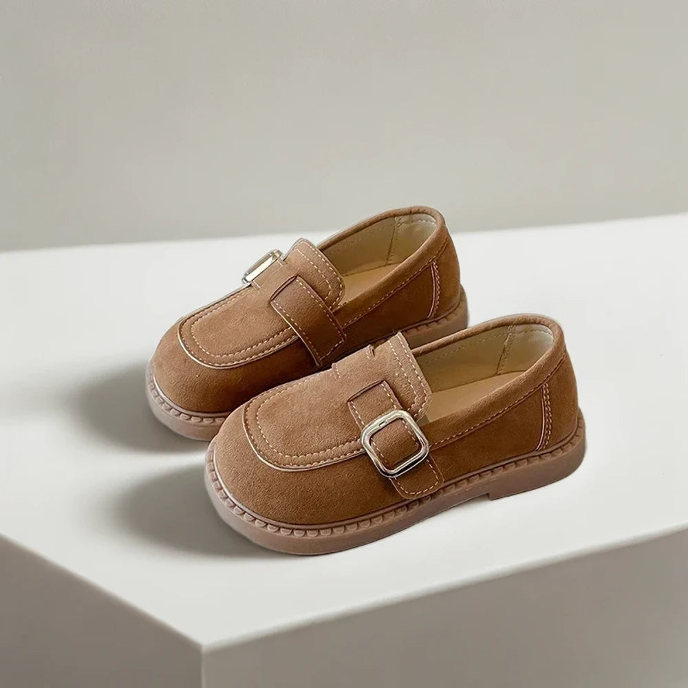 Mocassin marron foncé enfant porté lors d'une sortie scolaire en extérieur