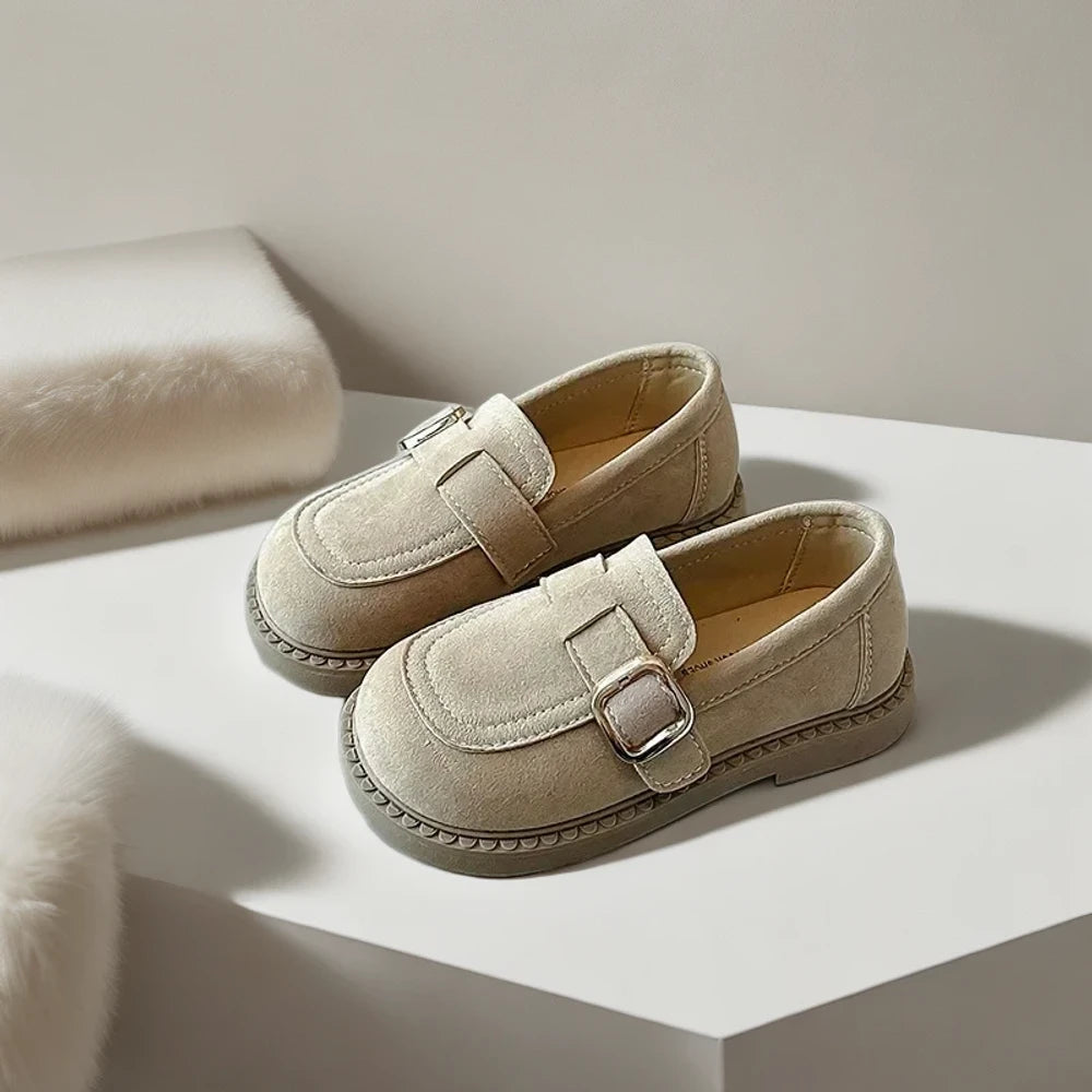 Enfant portant mocassins marron foncé assis confortablement en classe