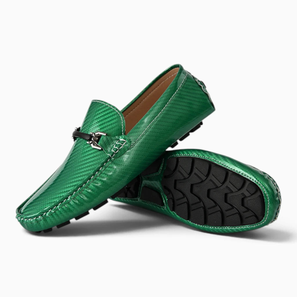Paire de mocassins vert avec semelle noire et boucle ornementale, vue de dessus montrant le détail de la texture et du talon