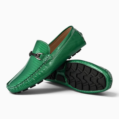 Paire de mocassins vert avec semelle noire et boucle ornementale, vue de dessus montrant le détail de la texture et du talon